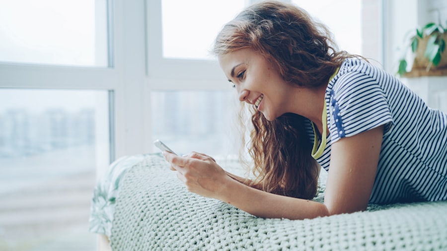 Mujer sonriendo mientras mira su teléfono en casa